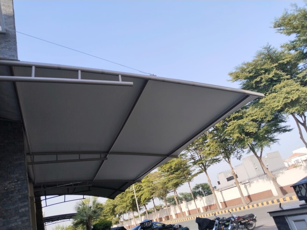 Modern charcoal tensile shade with greenery